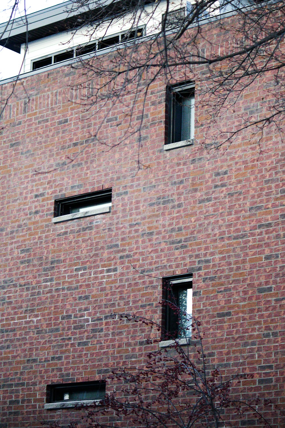 a red brick building with two windows and a clock