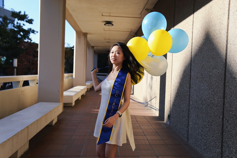 a woman is holding a bunch of balloons