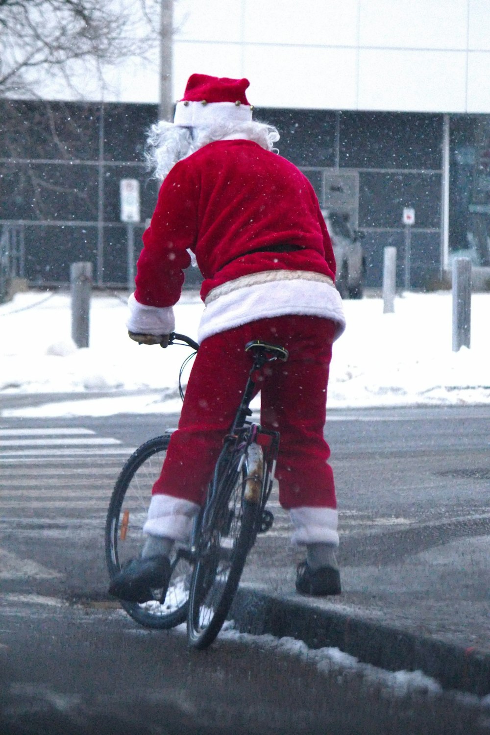 Ein Mann, der als Weihnachtsmann verkleidet ist und Fahrrad fährt