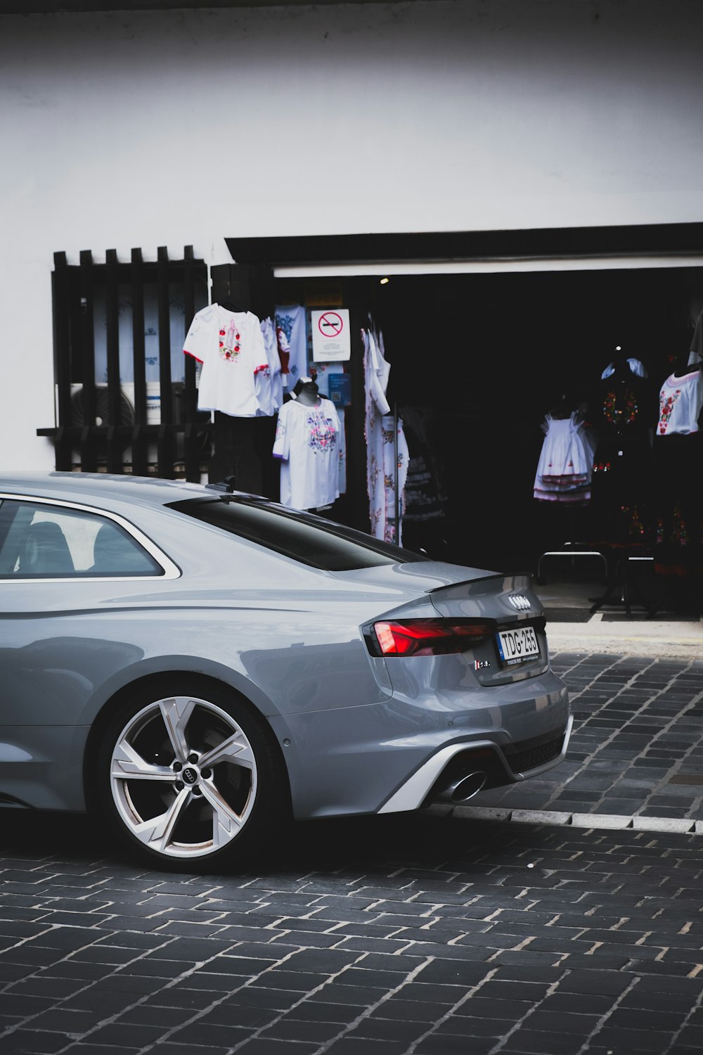 a silver car parked in front of a store