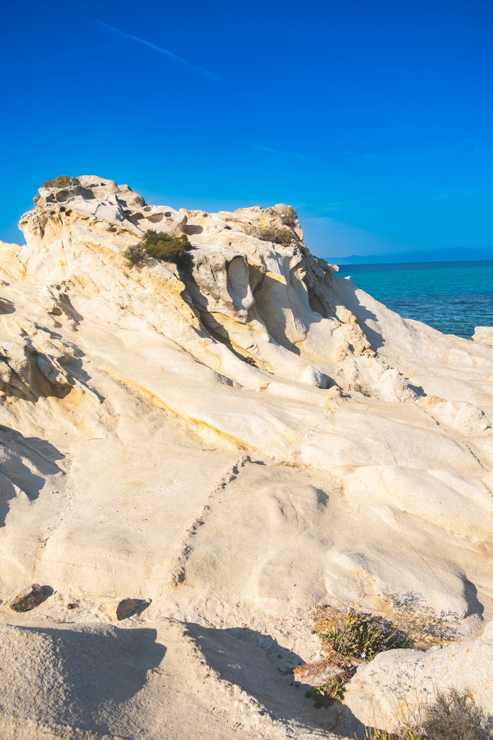 un homme chevauchant une planche de surf au sommet d’une plage de sable