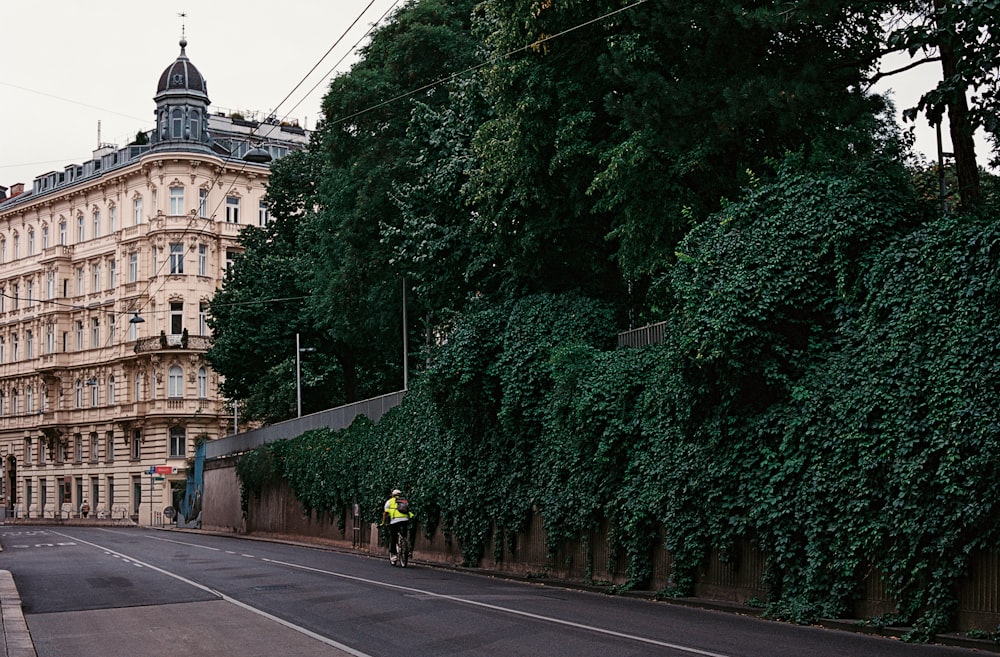 a man standing on the side of a road next to a tall building