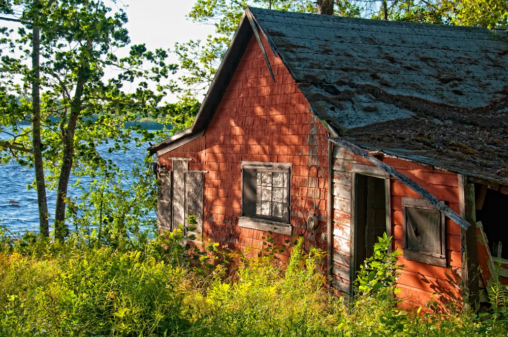 an old red building sitting next to a body of water