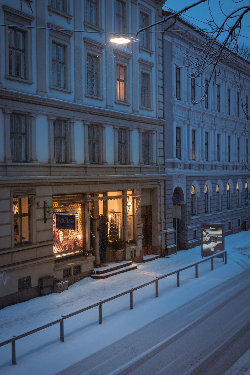 a snowy street with a building in the background