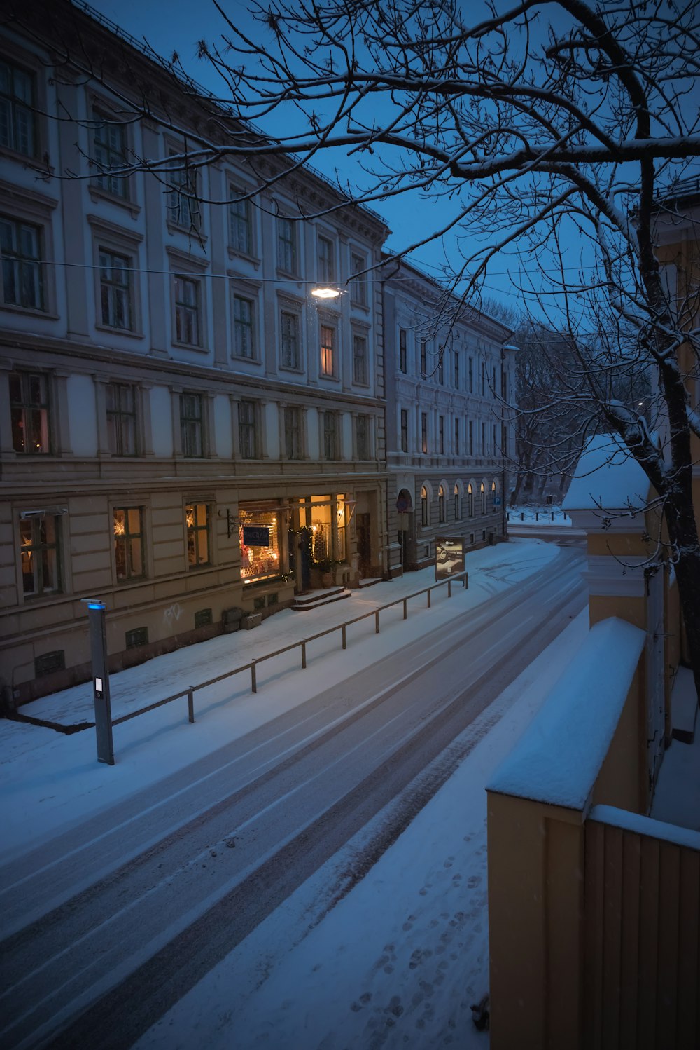 a city street is covered in snow at night
