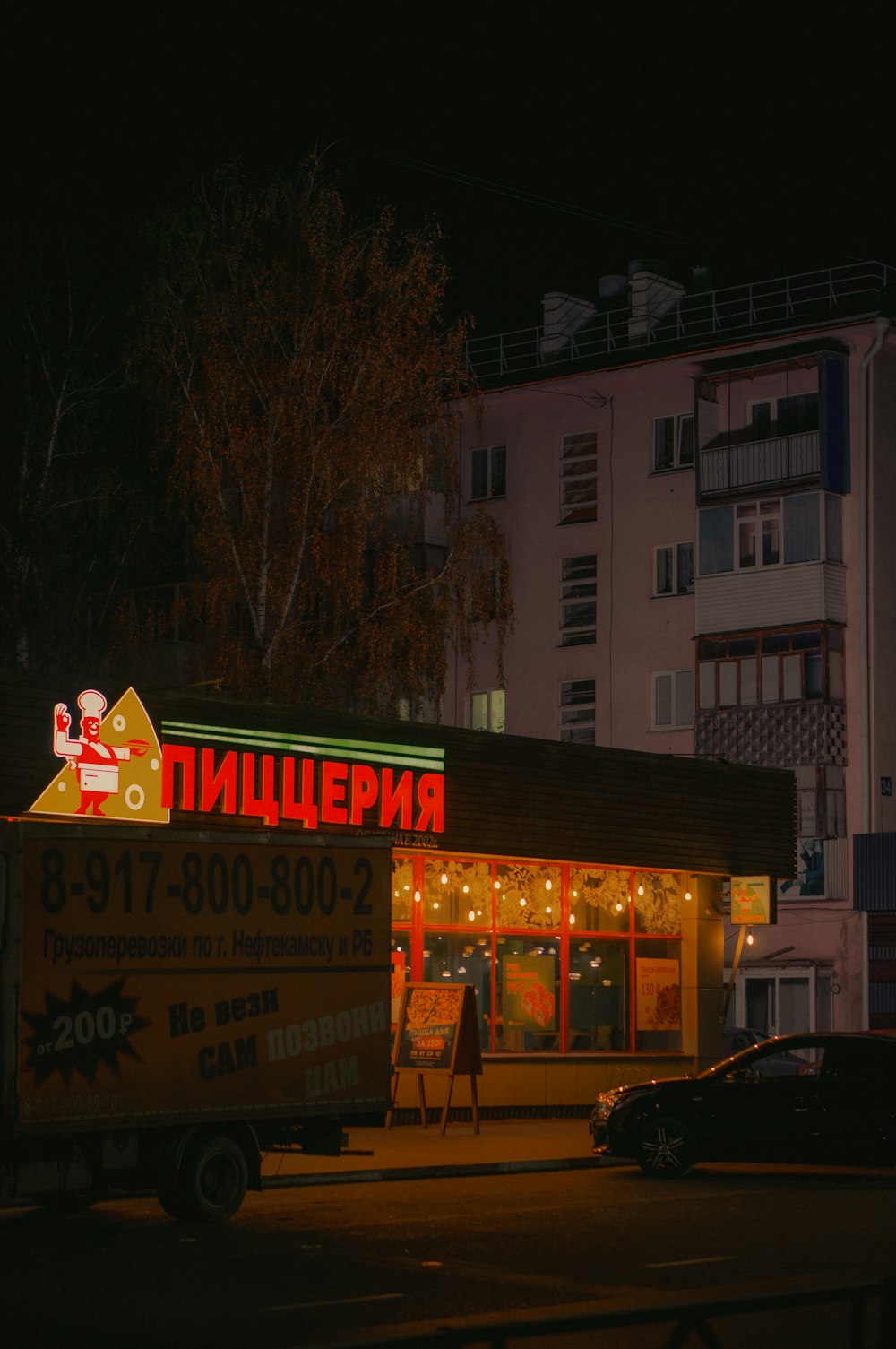 a truck parked in front of a building at night