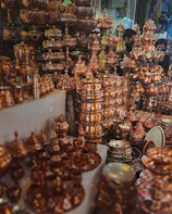 A collection of copper household decorations arranged on a wooden table