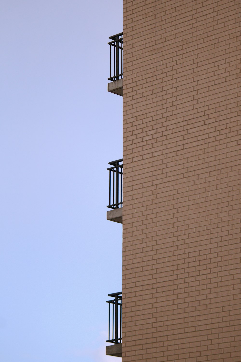 a tall brick building with balconies and a clock