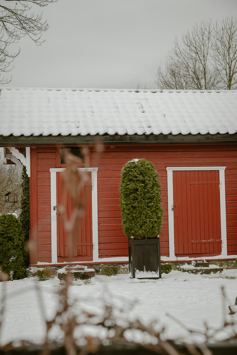 une grange rouge avec un toit blanc et des portes rouges