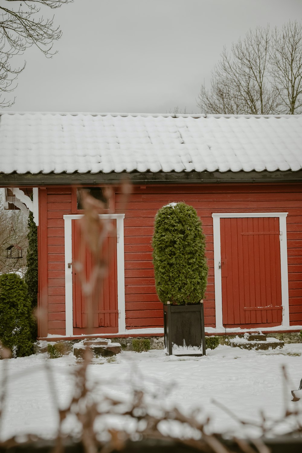 a red barn with a white roof and red doors