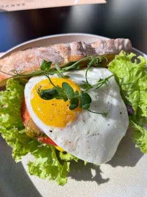 A colorful and appetizing breakfast sandwich with fresh ingredients on rustic bread.