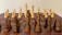 Elegant black and gold chess pieces set on a sleek, dark wooden board.