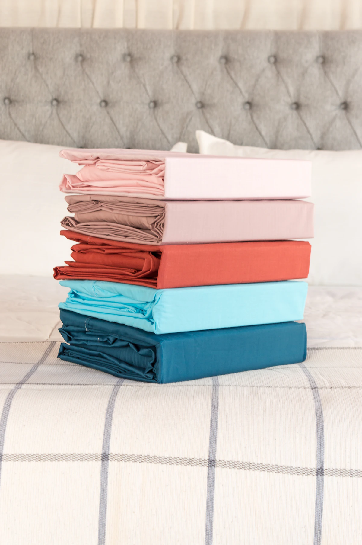 Folded sheet sets and fitted sheets arranged on a bed
