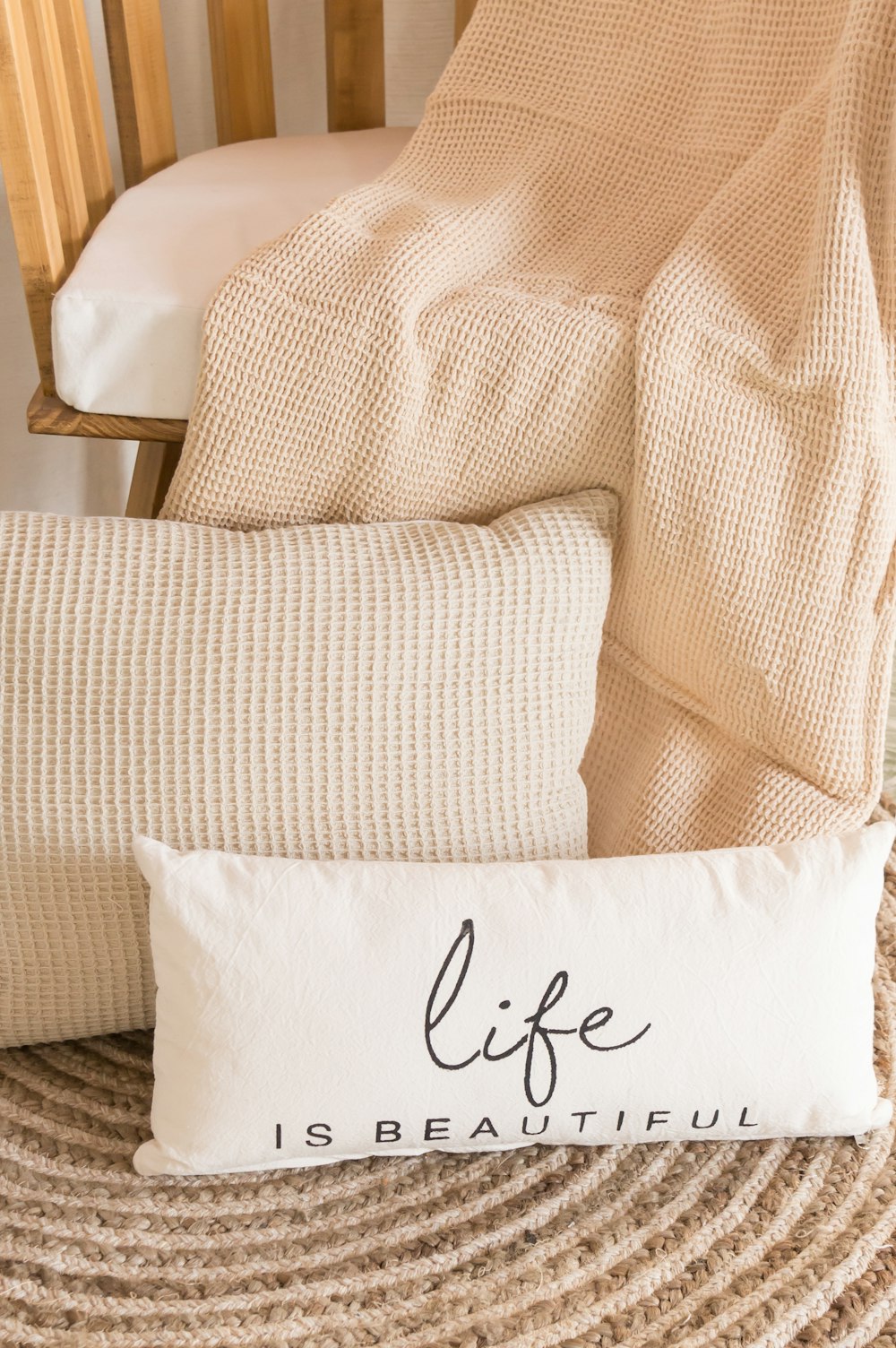 a white pillow sitting on top of a bed next to a chair