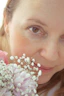 A smiling woman holding a beautiful pastel pink flower bouquet from Luvina Hoa.