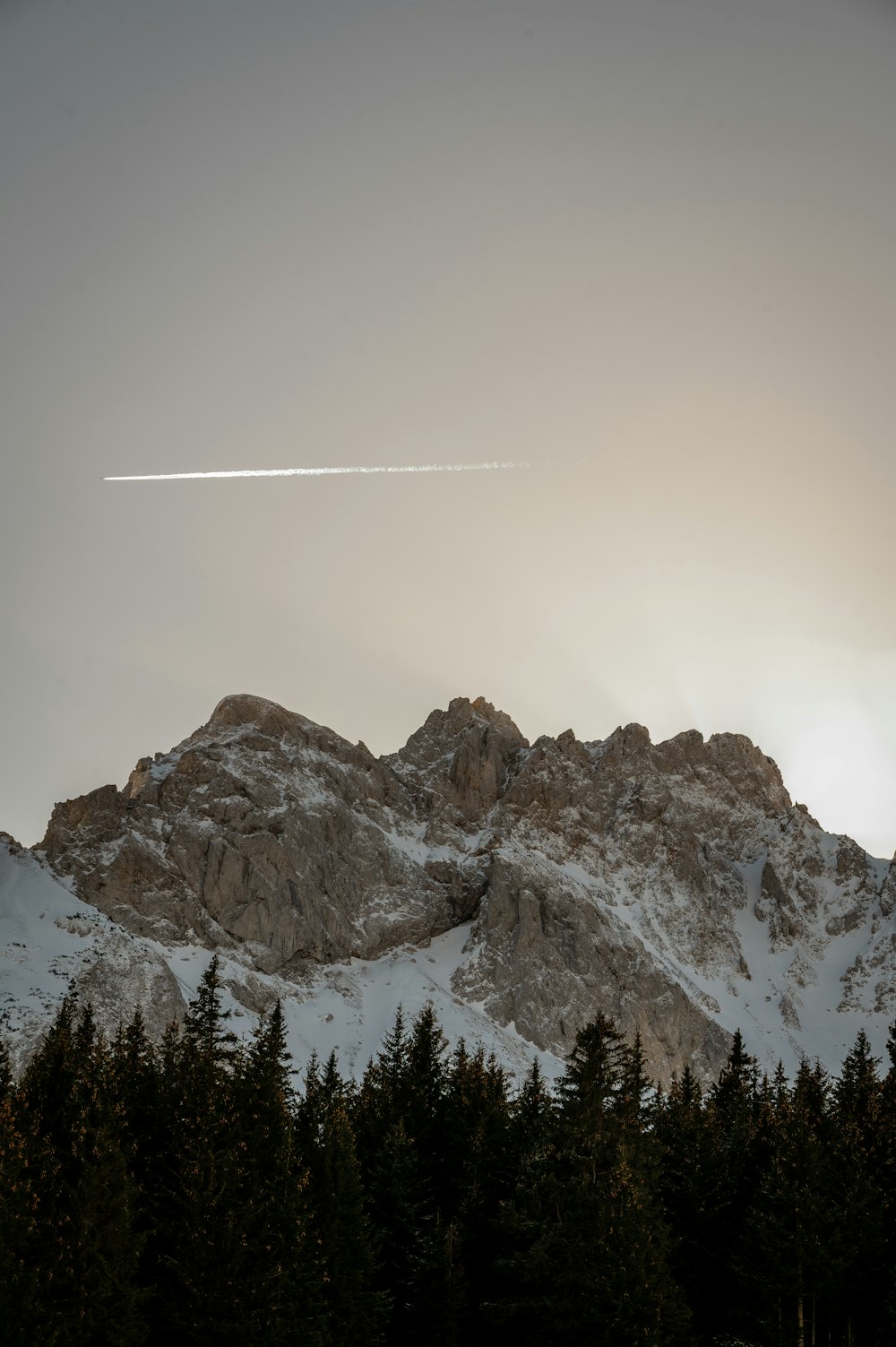 a plane is flying over a snowy mountain