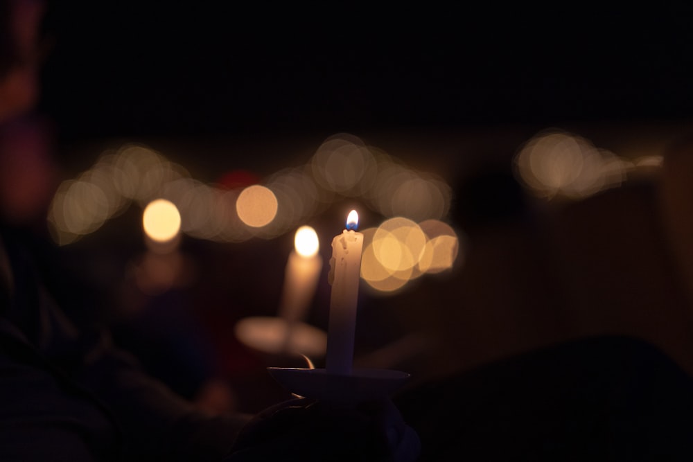 a person holding a lit candle in their hand