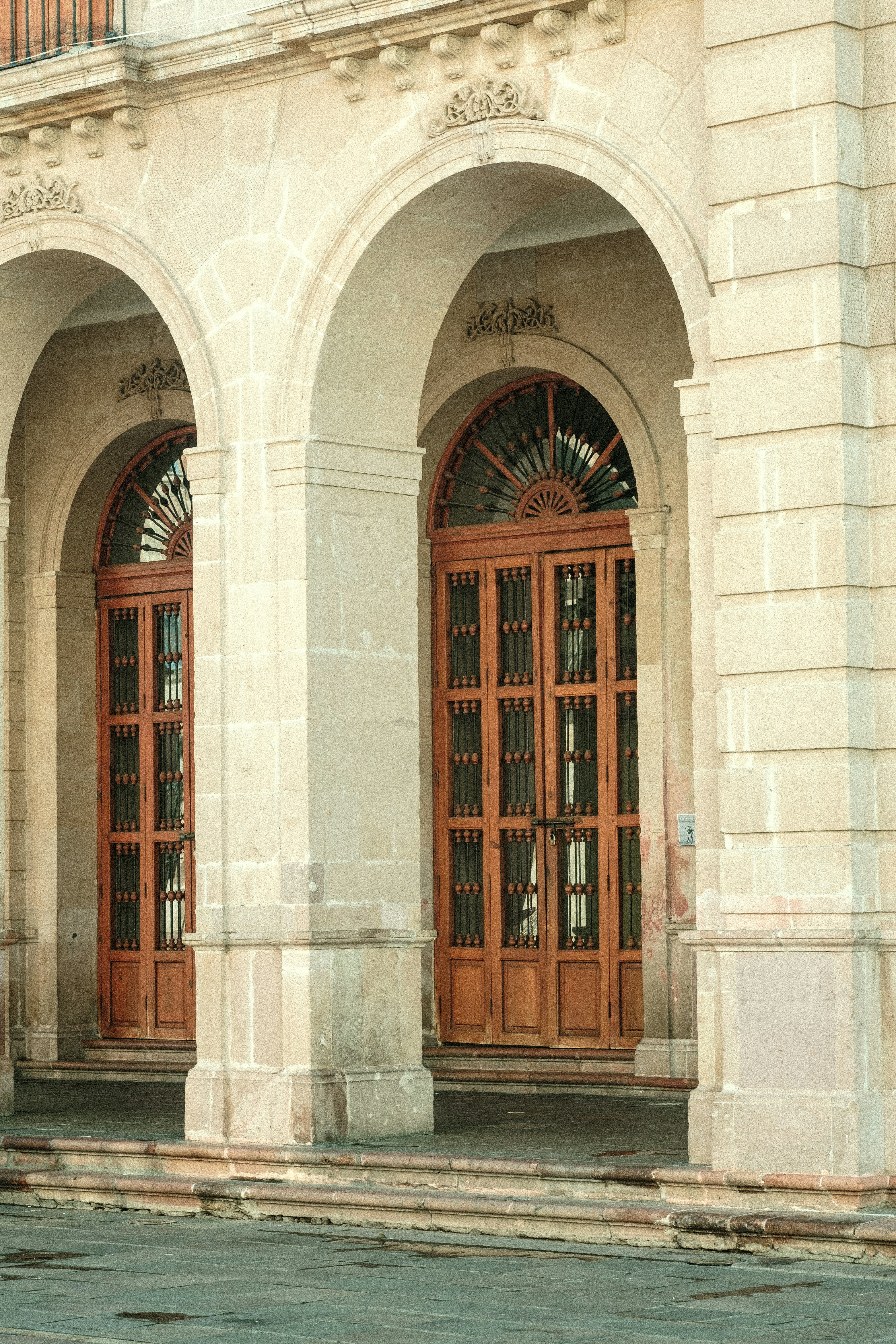 a man riding a bike down a street next to a tall building