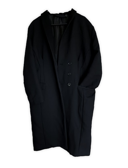 A long black coat featuring a minimalist design with a single-breasted button closure. The coat has two large front pockets and appears to be made of a heavy fabric suitable for colder weather.