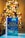 A book titled 'The Christmas Wish' by Nora Roberts is prominently displayed in the foreground, resting on a flat surface. The background features a warmly lit Christmas tree adorned with lights and ornaments, creating a cozy and festive atmosphere.