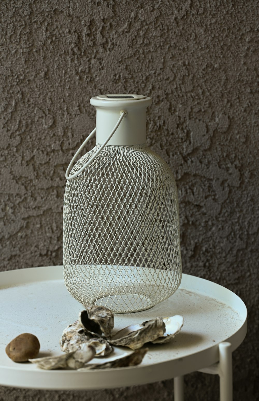 a white vase sitting on top of a white table