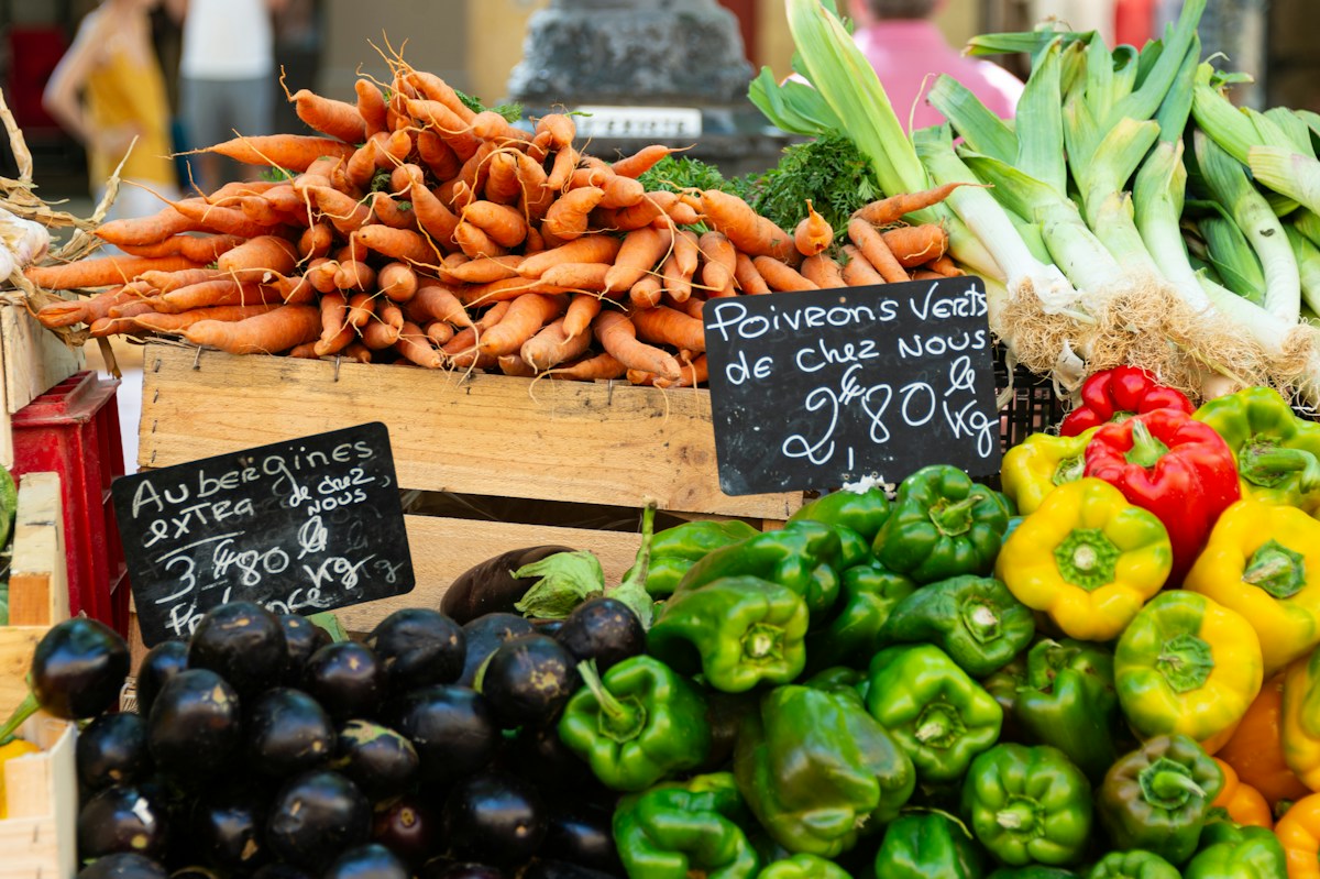 Frisches Gemüse mit handgeschriebenen Preisschildern auf einem Marktstand