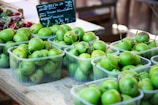 Freshly harvested pears displayed on wooden crates in an outdoor market setting.