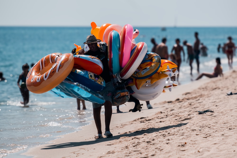 um homem carregando um monte de pranchas de surf em uma praia