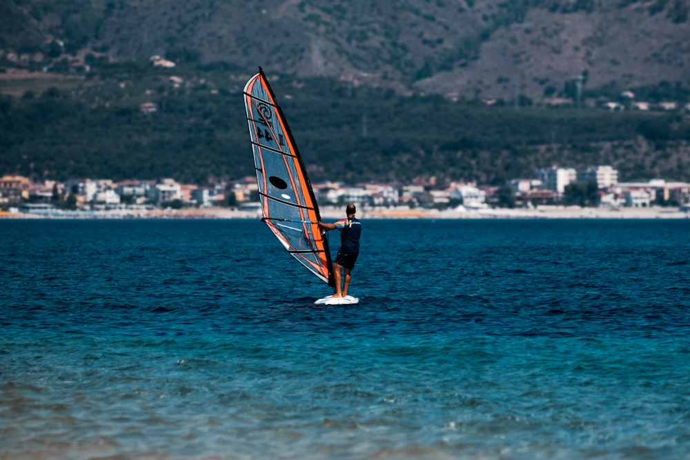 una persona montando una tabla de surf en un cuerpo de agua