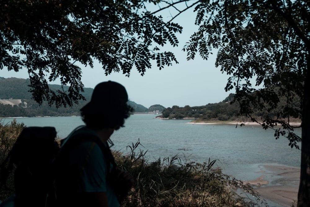 a person with a backpack looking out over a body of water