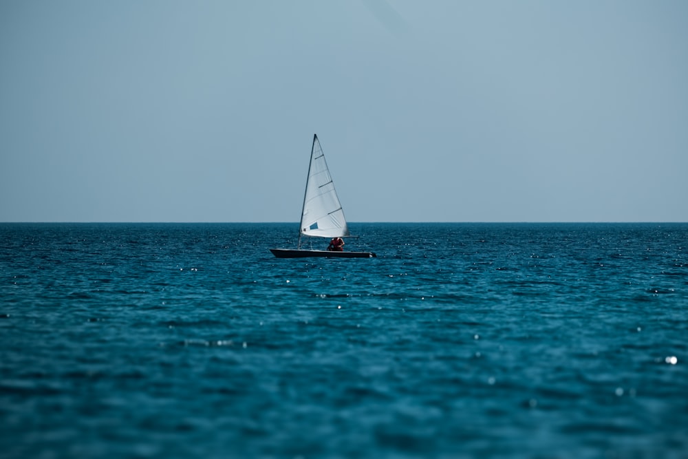 a small sailboat in the middle of a large body of water