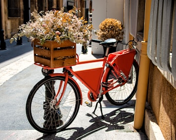a red bicycle with a basket full of flowers