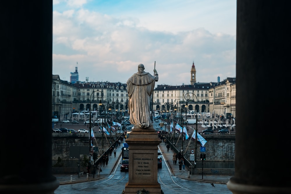 a statue of a man standing in front of some buildings