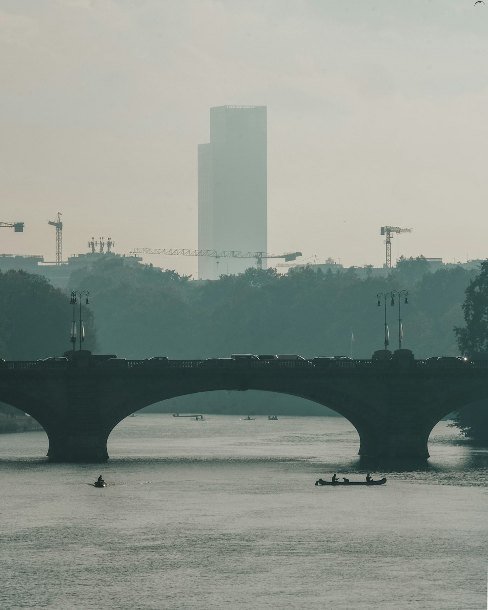 a bridge over a body of water with a tall building in the background