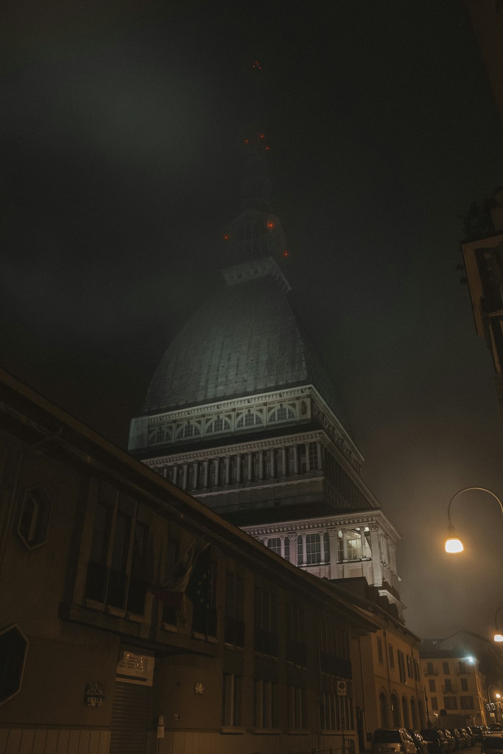 Ein sehr hohes Gebäude mit einem Glockenturm in der Nacht