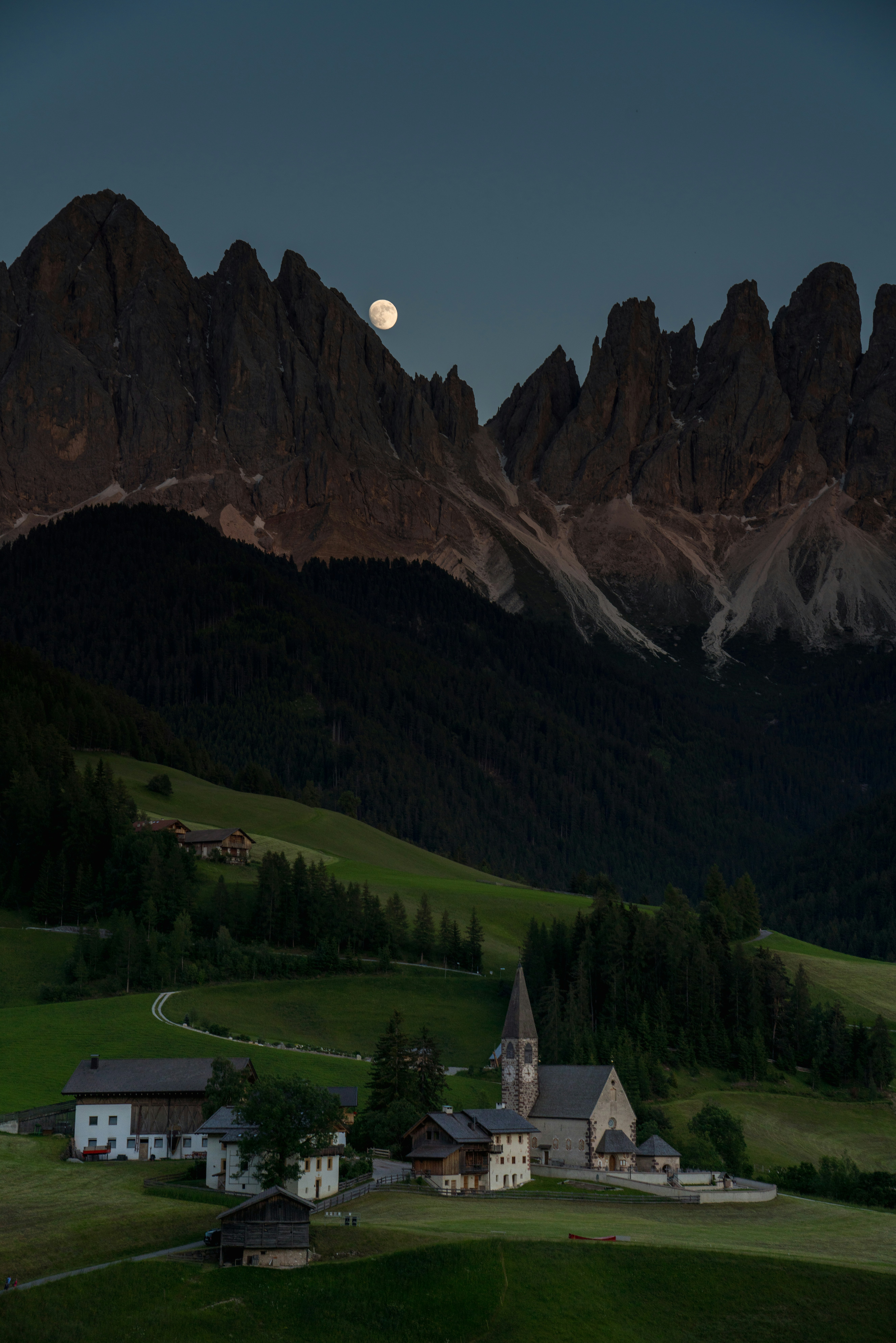 a small church in the middle of a green field