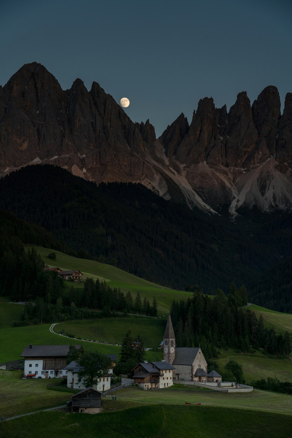 a small church in the middle of a green field