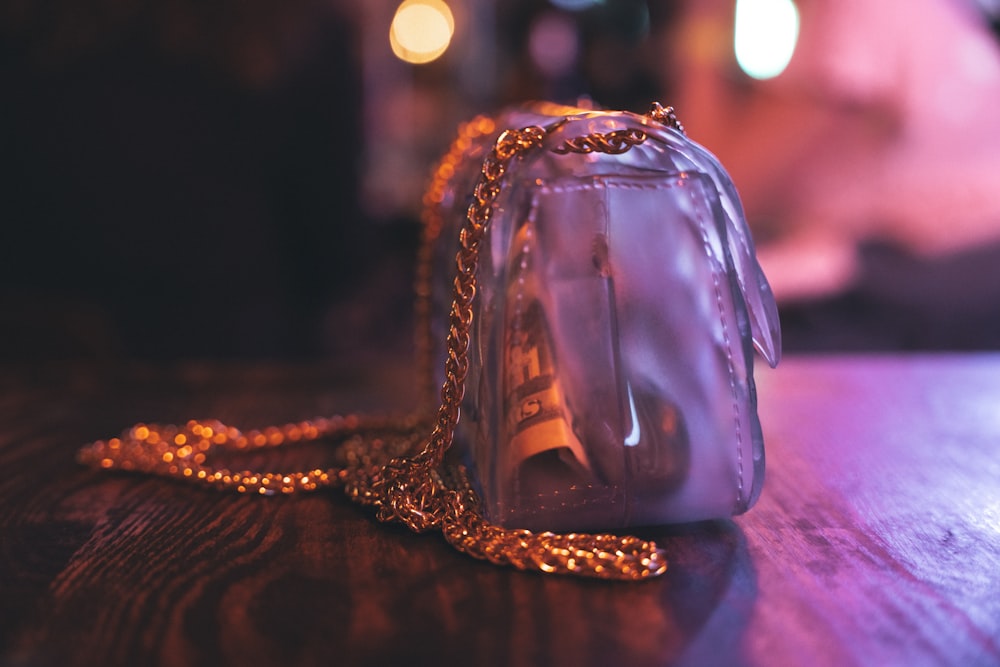 a clear purse sitting on top of a wooden table