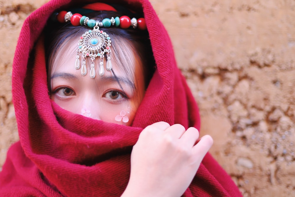 a woman wearing a red shawl and a head piece