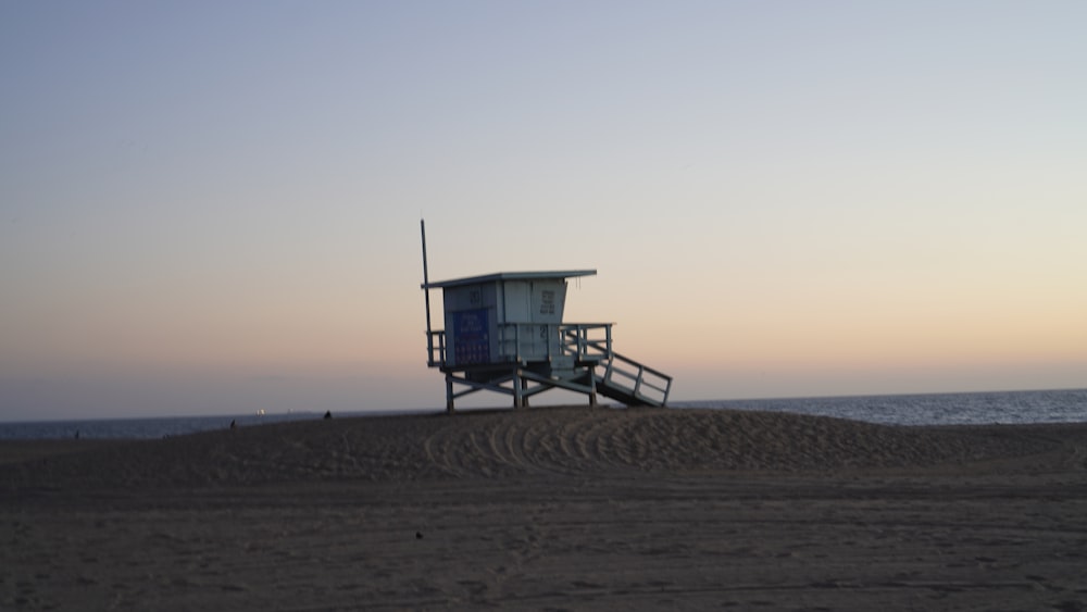 a lifeguard tower sitting on top of a sandy beach