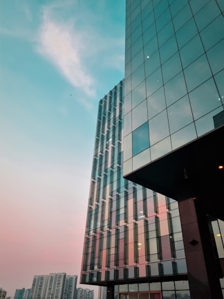 Architectural close-up of a glass skyscraper reflecting the Caribbean sky at dusk.