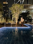 Night view of a luxury hotel rooftop pool lit with soft ambient lights.