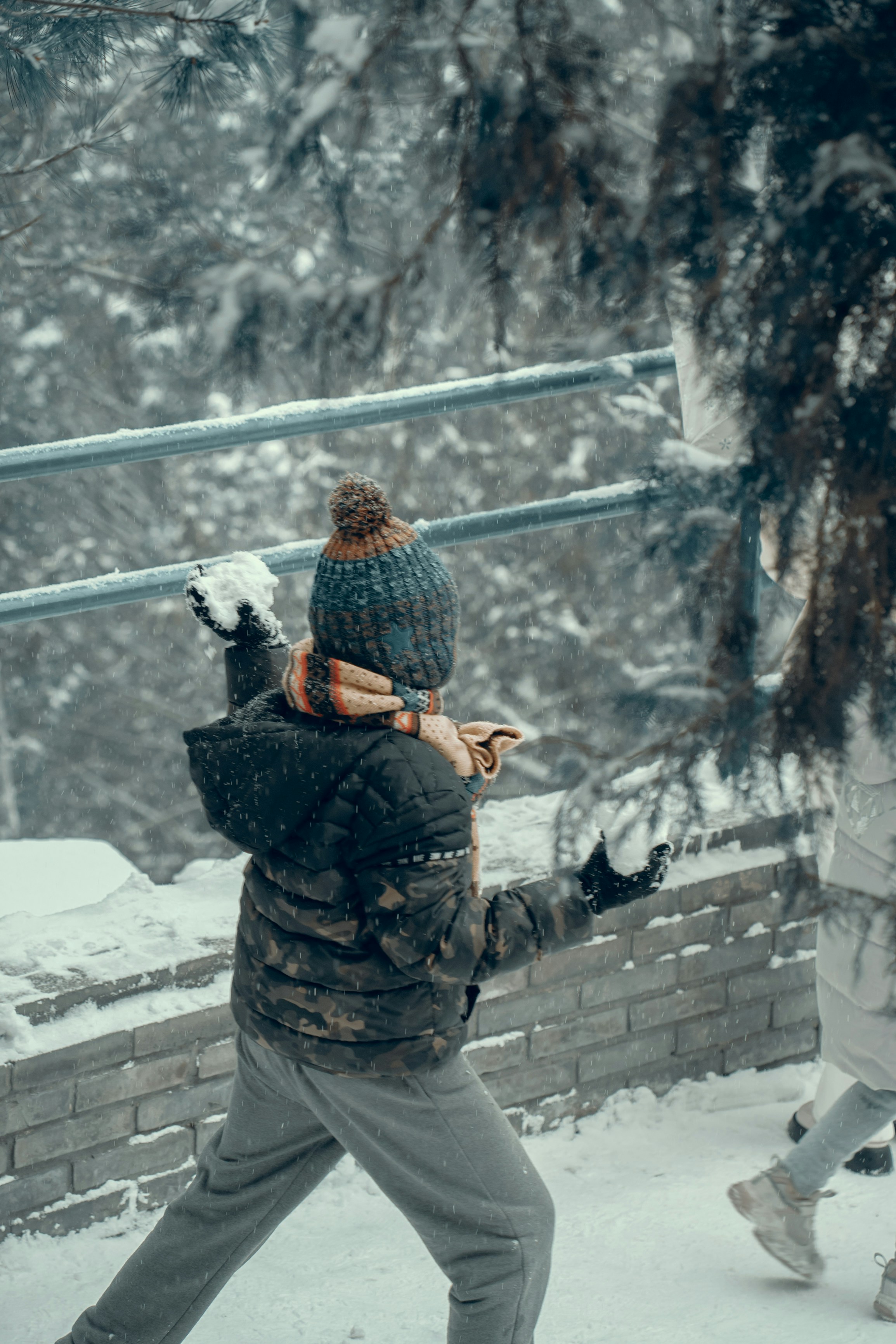 a person walking in the snow carrying a child