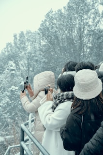 Group of friends enjoying a joyful Christmas photo session outdoors with snow