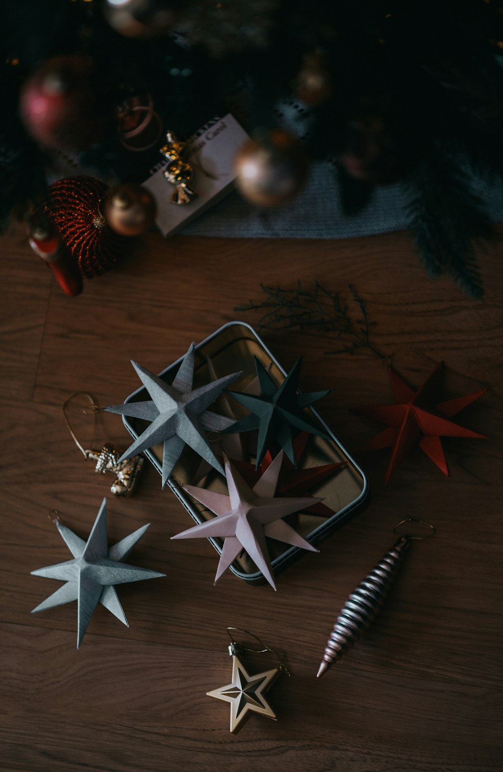 a wooden table topped with ornaments and a christmas tree