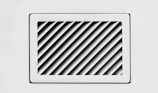 A rectangular, white air vent is mounted on a white wall. The vent has diagonal slats that create a dynamic pattern of shadows and light.