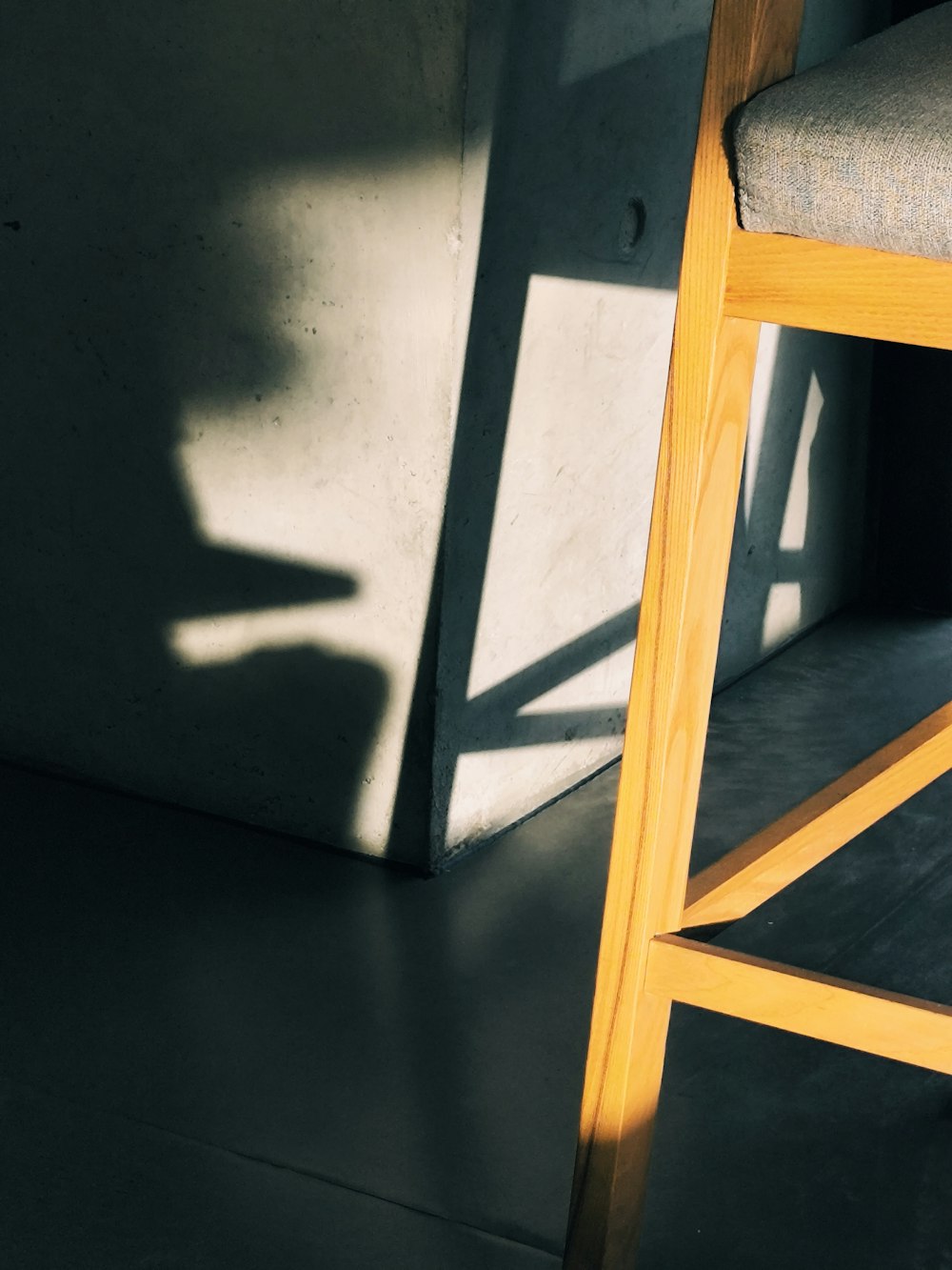 a wooden chair sitting next to a wall