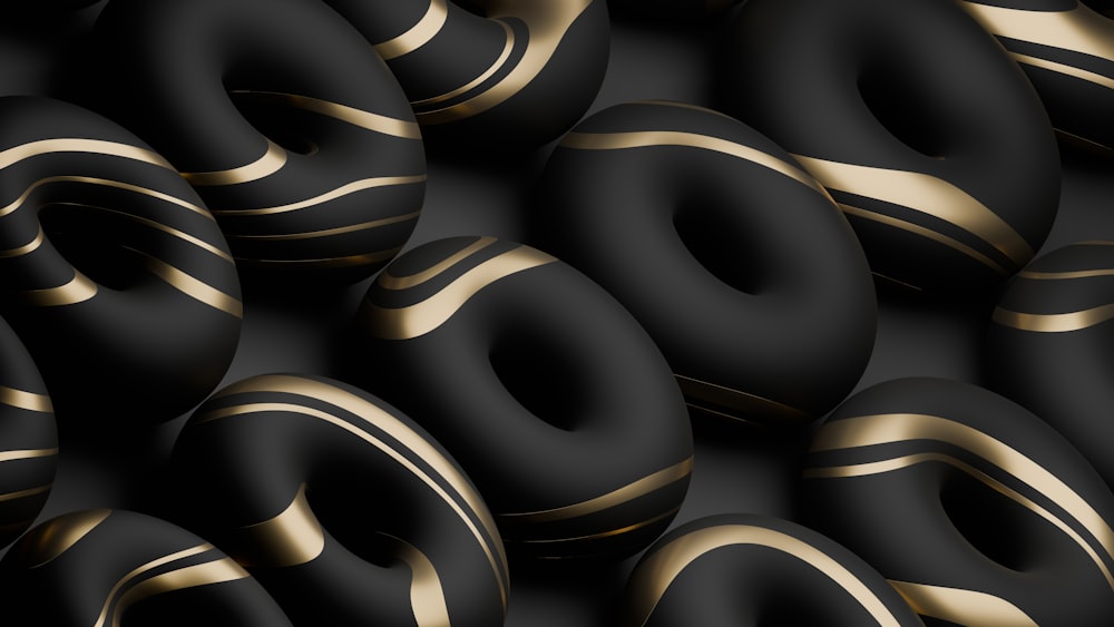 a bunch of black and gold donuts stacked on top of each other