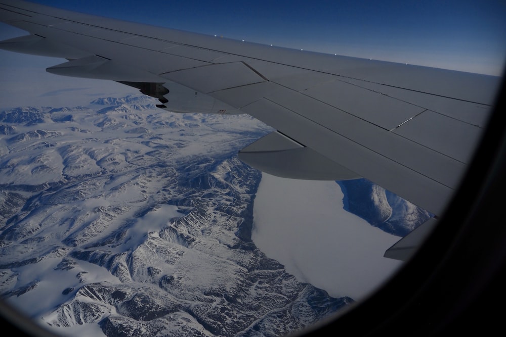 the wing of an airplane flying over a mountain range