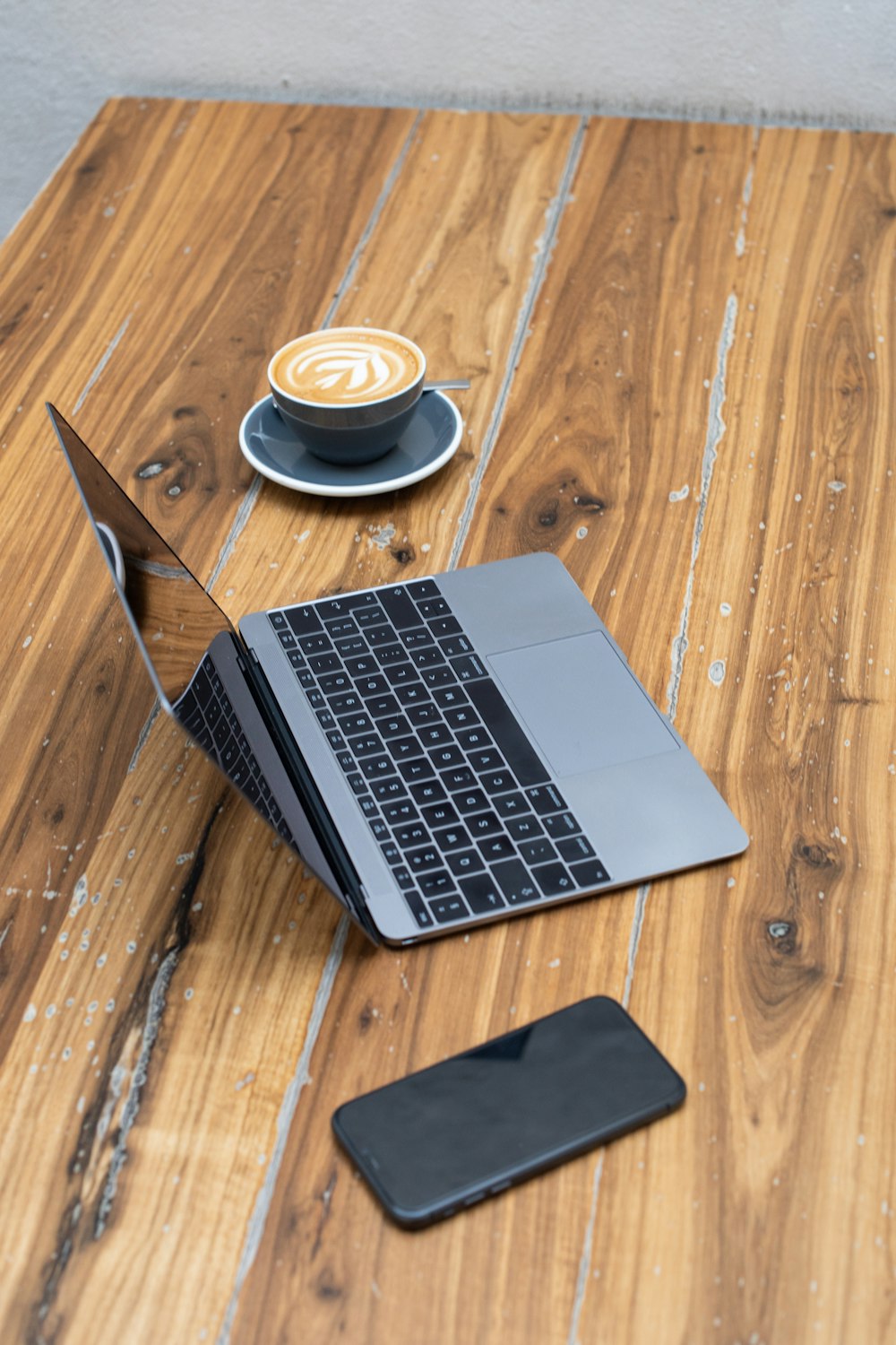 a laptop computer sitting on top of a wooden table